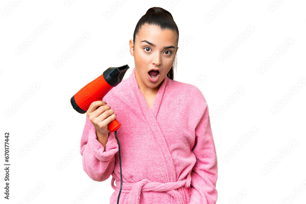 Young woman in a bathrobe holding a hairdryer over isolated chroma key background with surprise and shocked facial expression Young woman in a bathrobe holding a hairdryer over isolated chroma key background with surprise and shocked facial expression