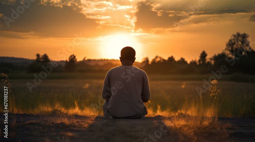 silhouette of a person kneeling in prayer, with a golden sunset in the background, creating a sense of peace and devotion. generative AI photo