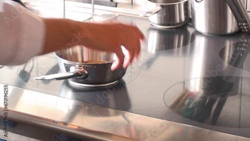 Un cuoco prepara un brodo in una cucina professionale photo