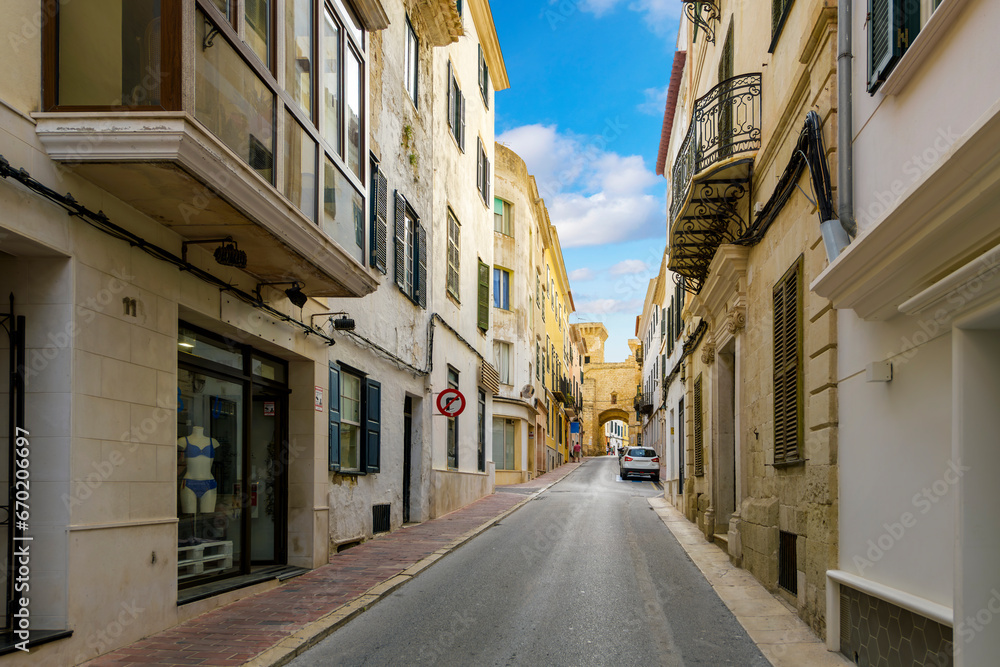 A street of apartments leads to the historic Portal de San Roque, the archway that is one of the last remnants of the old city walls of Mahón, Spain, on the Mediterranean island of Menorca.	