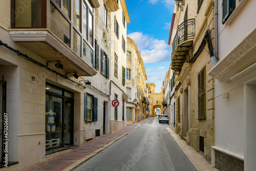 A street of apartments leads to the historic Portal de San Roque, the archway that is one of the last remnants of the old city walls of Mahón, Spain, on the Mediterranean island of Menorca. 