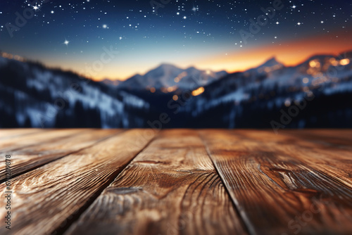 A wooden table boards and blurred defocused snowing mountains view in the background at night. photo