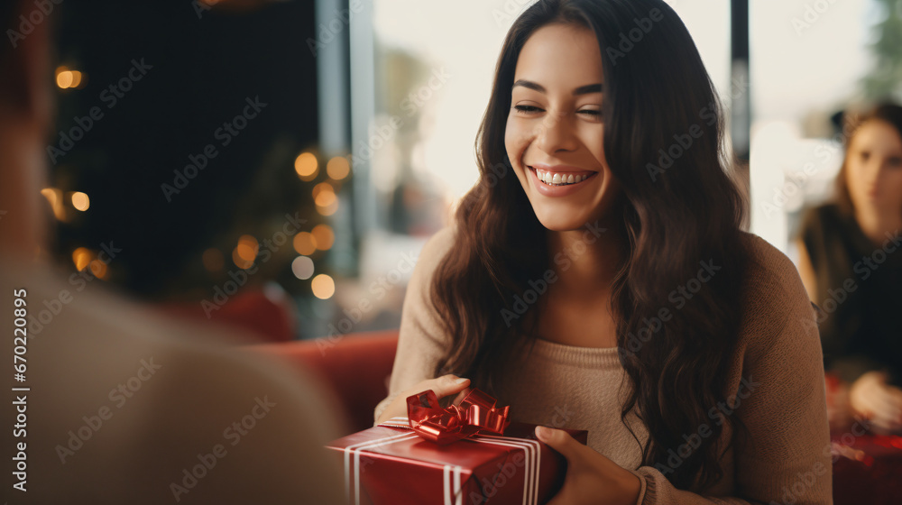Laughing woman handing over gift to friend - obrazy, fototapety, plakaty 