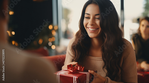 Laughing woman handing over gift to friend