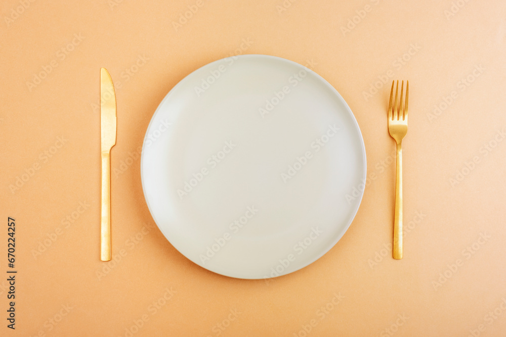 Empty plate with fork and knife on orange background. Diet concept. Top view, flat lay Empty plate with fork and knife on orange background. Diet concept. Top view, flat lay