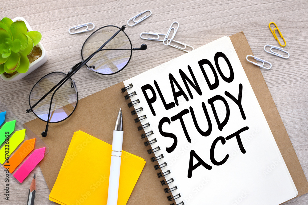 Plan Do Study Act top view of an open notebook with stickers and plants ...