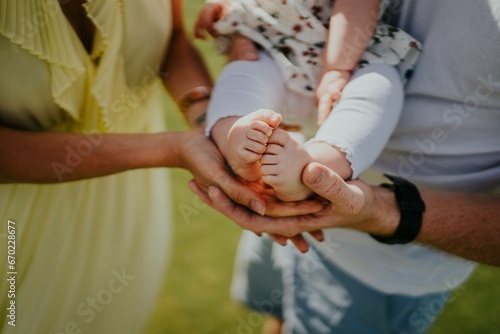 Parents holding the legs of a newborn