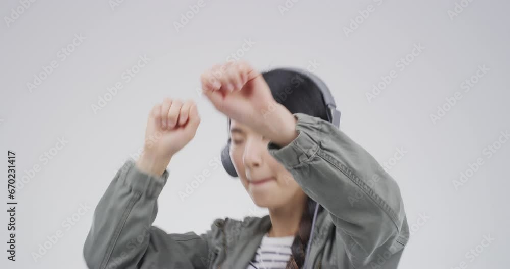 Asian woman, headphones and dance to music for student wellness, streaming service and kpop song in studio. Young Korean person with audio, electronics and listening with energy on a white background Asian woman, headphones and dance to music for student wellness, streaming service and kpop song in studio. Young Korean person with audio, electronics and listening with energy on a white background