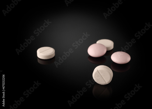 white and pink pills on a dark background