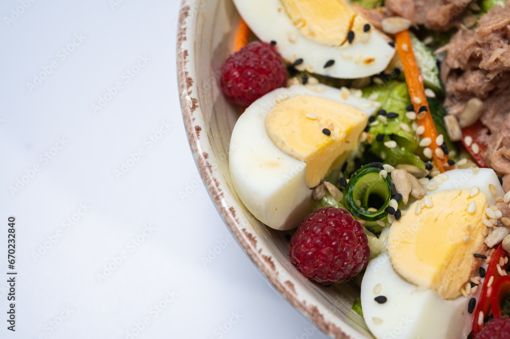 tuna salad with lettuce and eggs, lamb and fruit, fresh salad in a plate on a white background tuna salad with lettuce and eggs, lamb and fruit, fresh salad in a plate on a white background