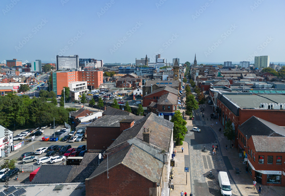 Fototapeta premium Preston, Lancashire, UK, September 06, 2023; high aspect aerial view of Fishergate high street shopping and over the town cityscape of Preston, Lancashire, England.
