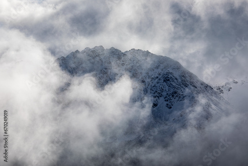 Mountain peak emerge through the misty clouds at swiss alps near Davos, Switzerland