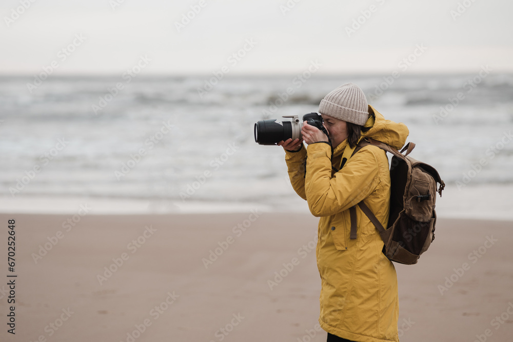 Tourist traveler photographer taking pictures landscape over north sea background