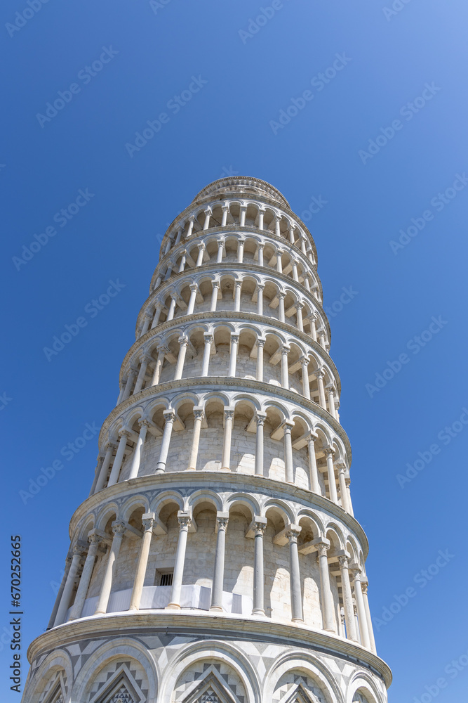 The leaning tower of Pisa, Italy in perspective shot from the ground. Summer day, clear blue sky and sunny