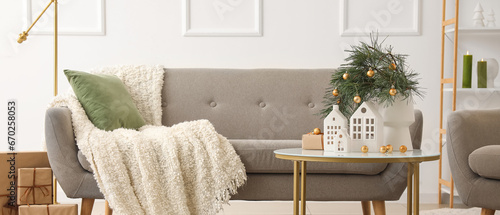 Grey sofa with Christmas decorations in light living room