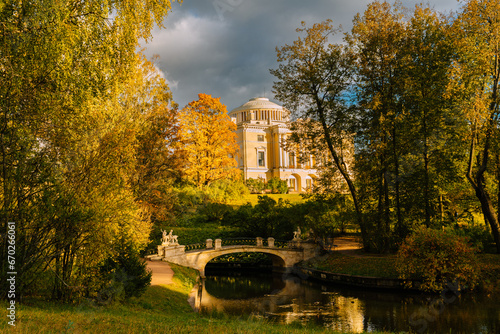 Pavlovsky Palace and Centaur Bridge in autumn in Pavlovsky Park. Colorful autumn foliage and river in park. 