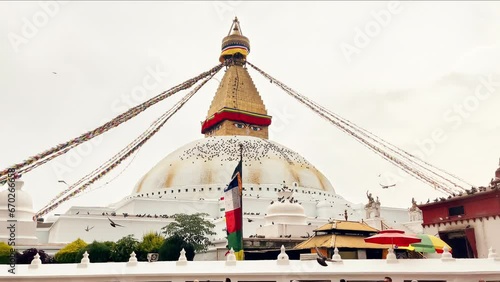 Slow motion 4K footage of pigeons flying around Boudhanath Stupa with waving Buddhism prayer flags. in Kathmandu, Nepal. Very popular UNESCO World Heritage Site.