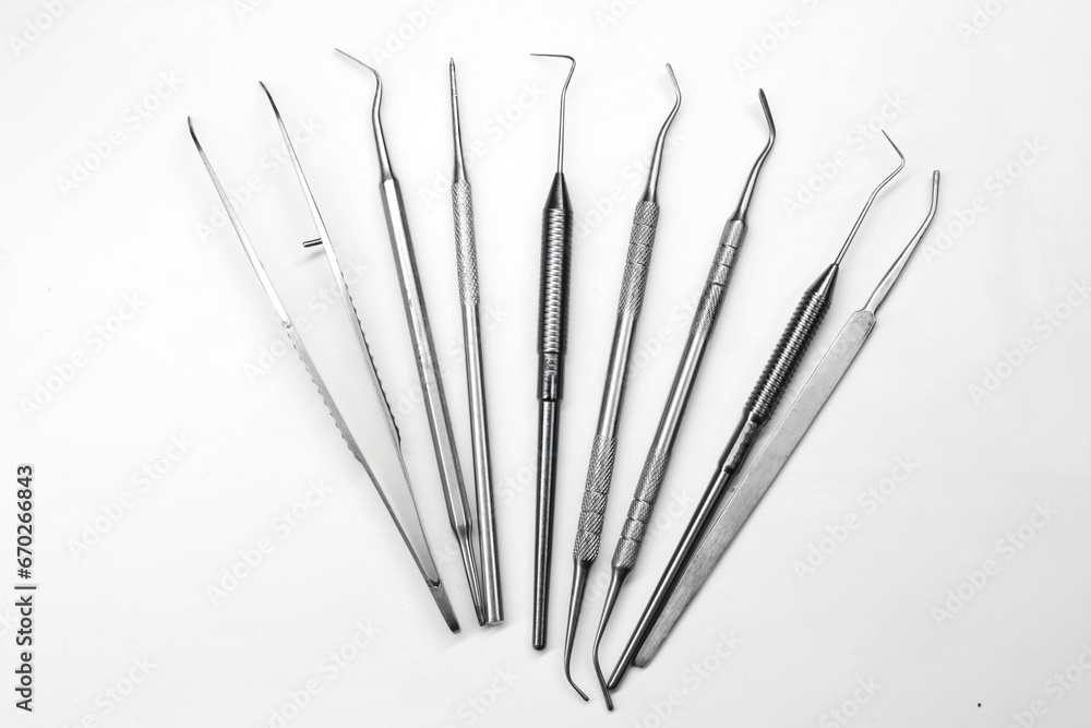 Metal stainless dentist instruments are fanned out on a white background Metal stainless dentist instruments are fanned out on a white background