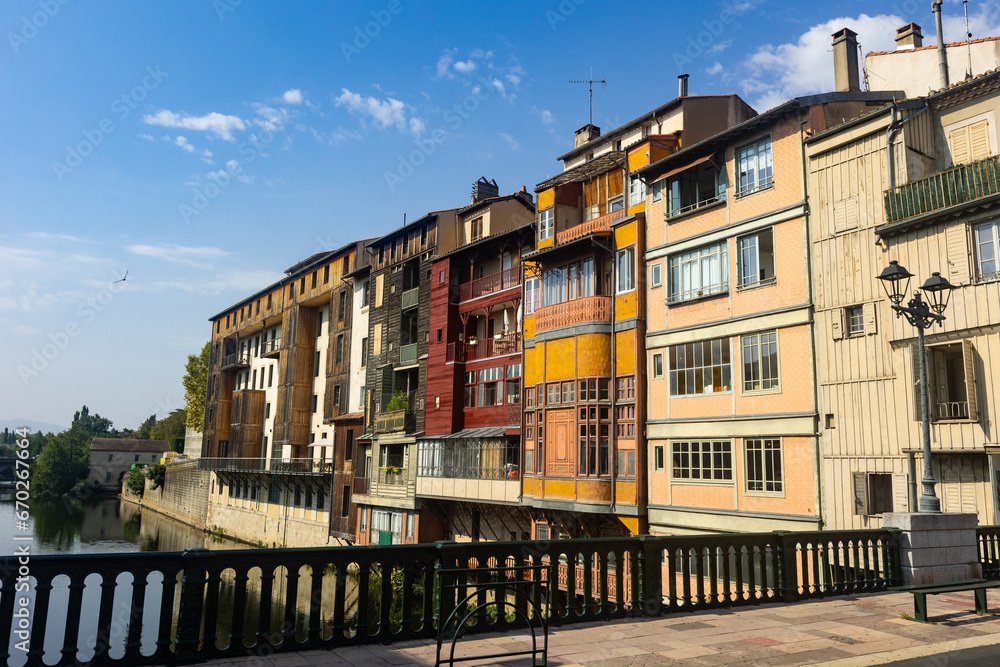 View from bridge of Castres townscape overlooking old colorful houses along Agout river on sunny summer day, Tarn department France
