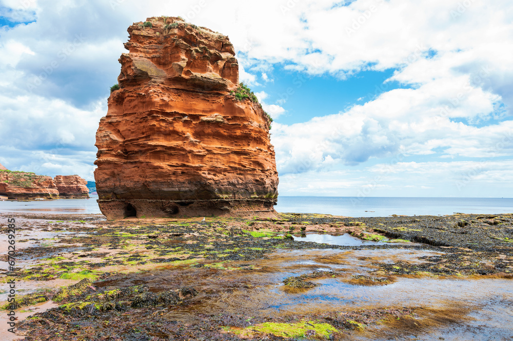 Rock formations in Ladram Bay, United Kingdom. View of the beach and red and orange cliffs and the sea, Jurassic coast, selective focus