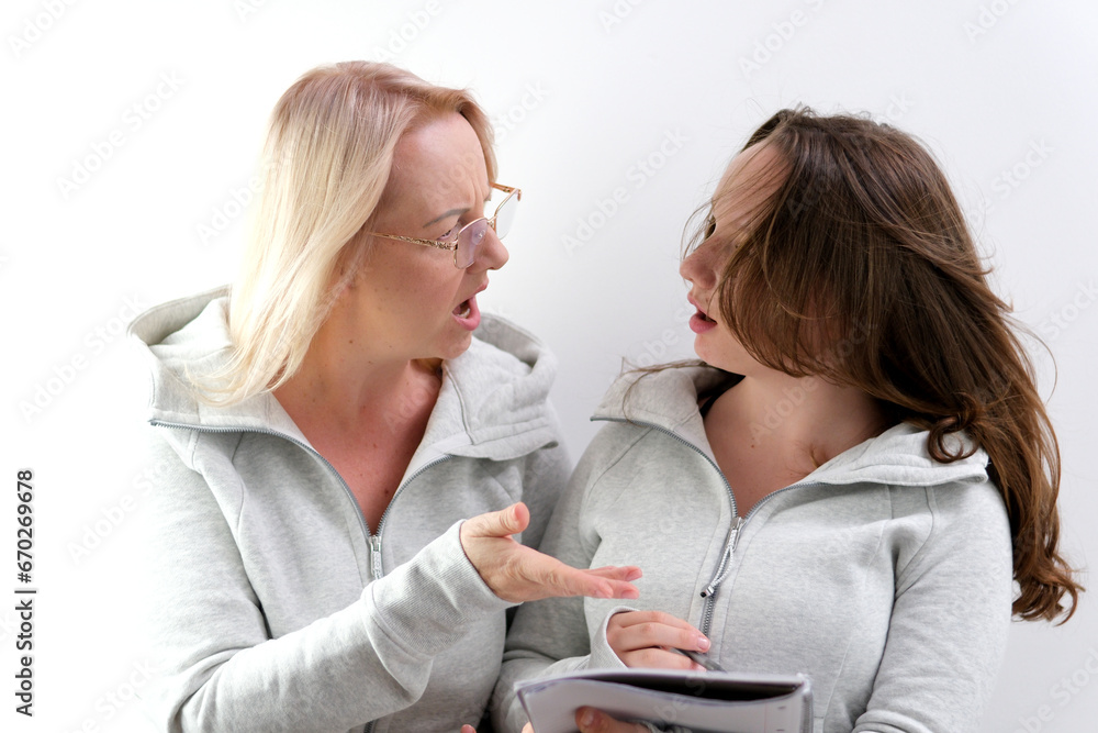 mom and daughter doing homework, woman wearing glasses, young teenage girl trying to write something, laughing, smiling, spending pleasant time, explaining to child, surprise, pointing with hand mom and daughter doing homework, woman wearing glasses, young teenage girl trying to write something, laughing, smiling, spending pleasant time, explaining to child, surprise, pointing with hand