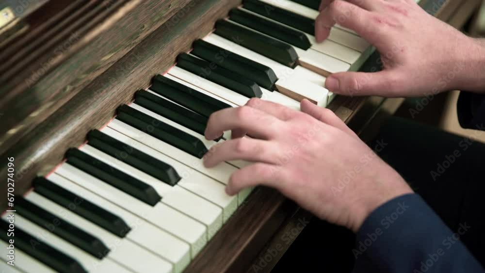 Close-up on the hands of a musician who performs a piano piece on an acoustic piano. Close-up on the hands of a musician who performs a piano piece on an acoustic piano.