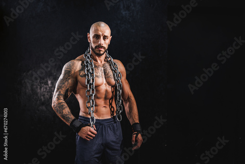 Fotografie Bodybuilder Standing In The Gym With Chains