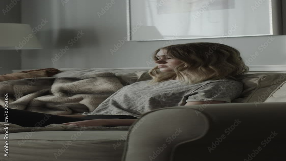 Girl sitting on sofa frustrated with social media on cell phone - vertical video / Cedar Hills, Utah, United States Girl sitting on sofa frustrated with social media on cell phone - vertical video / Cedar Hills, Utah, United States