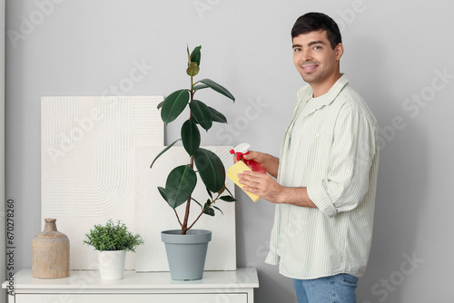 Young man wiping leaves of ...