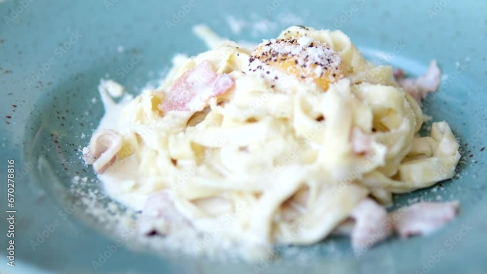 Pasta carbonara with parmesan cheese in clay plate isolated on wooden background Pasta carbonara with parmesan cheese in clay plate isolated on wooden background