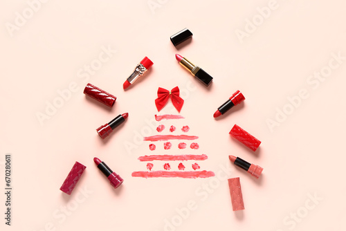 Christmas tree made of lipsticks and bow on pink background