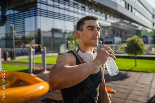 man young male athlete hold bottle of water drink training outdoor