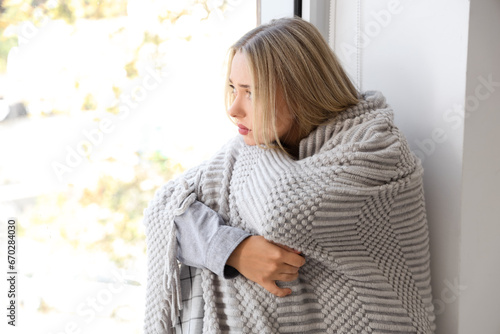 Young woman wrapped in cozy...