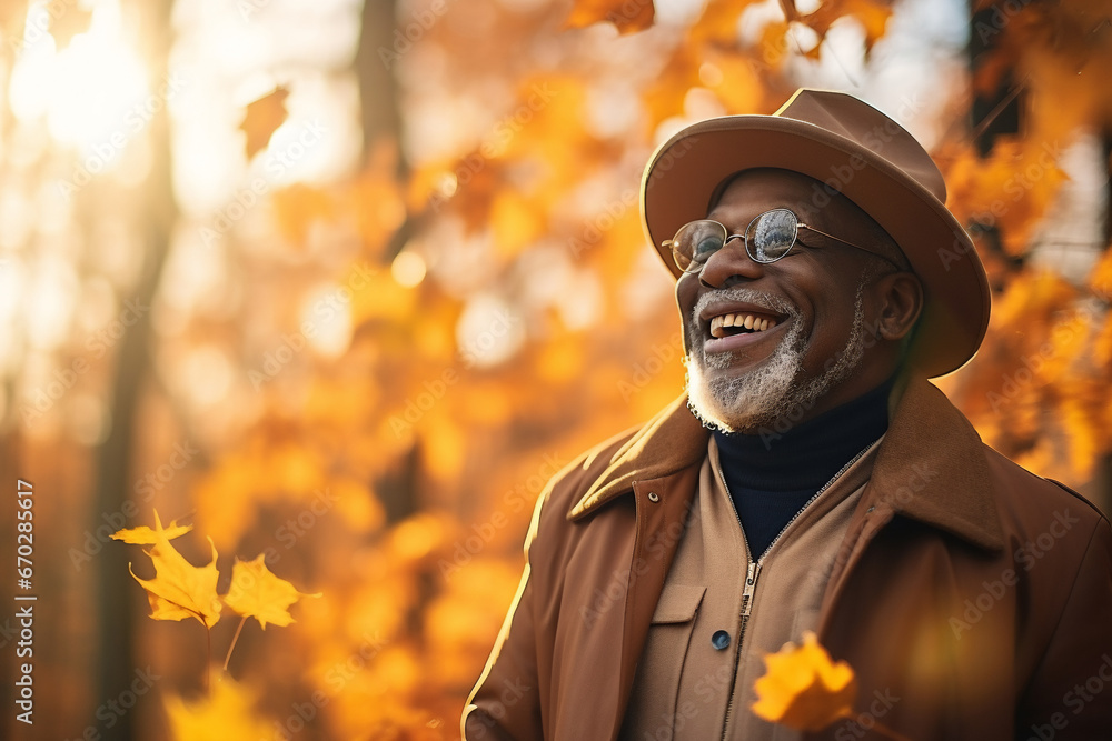 A senior african american man is playing with fallen leaves happily with an autumn coat in a forest during sunset in autumn with a vibrant coloration A senior african american man is playing with fallen leaves happily with an autumn coat in a forest during sunset in autumn with a vibrant coloration