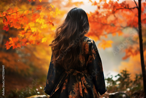 A young asian woman is walking happily with an autumn coat in a forest during sunset in autumn in a vibrant coloration photo