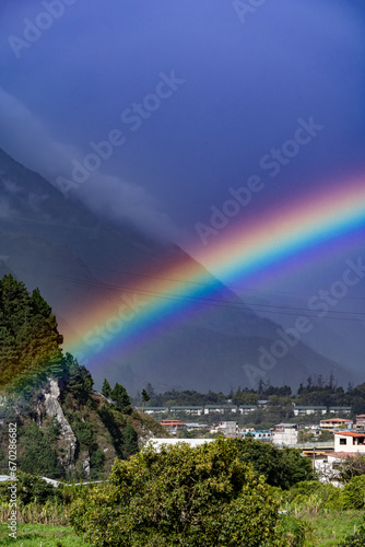 Beautiful view of the rainbow over the  volcanoes in the city of Banos  Ecuador. Amazing sunset.