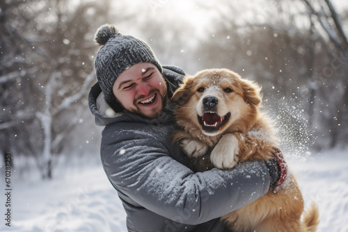 A young caucasian male is playing happily with the dog in the snow with in a winter coat with a winter hat in a in snow covered country landscape during day in winter while snowing