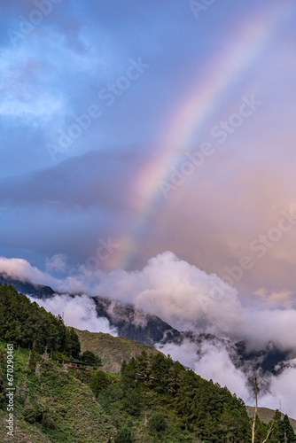 Beautiful view of the rainbow over the volcanoes in the city of Banos, Ecuador. Amazing sunset.