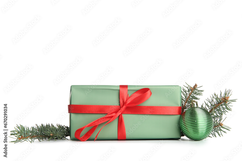 Gift box with Christmas ball and fir branches on white background
