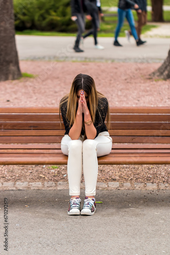 Sad girl on the bench praying