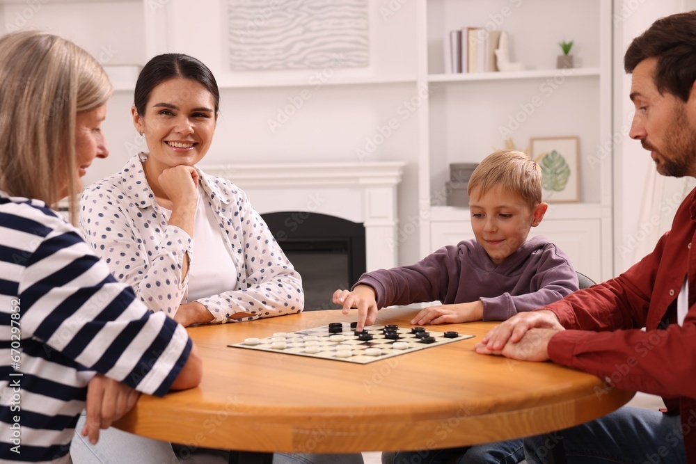 Family playing checkers at coffee table in room Family playing checkers at coffee table in room