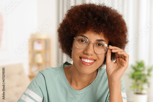 Portrait of happy young woman in eyeglasses indoors