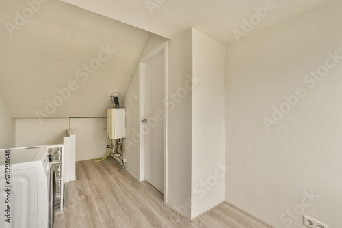 an empty room with white walls and wood flooring on the left side of the room, there is a washer in the