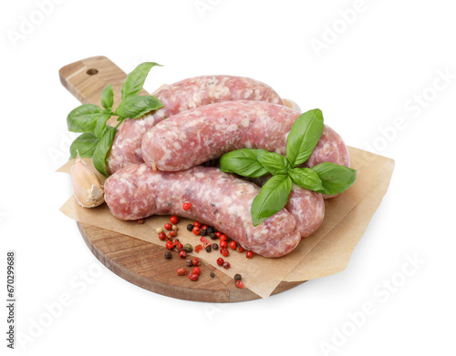 Wooden board with raw homemade sausages and different spices isolated on white