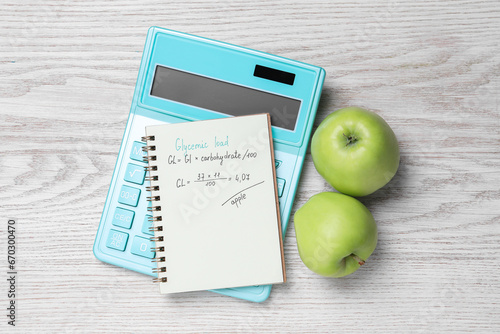 Fototapeta Naklejka Na Ścianę i Meble -  Notebook with calculated glycemic load for apples, calculator and fresh fruits on light wooden table, flat lay