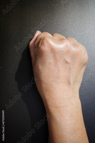 Woman's hand with fist gesture, Back right side, on black background, Asian body skin part, Symbol, Gesturing, Body Language Concept photo