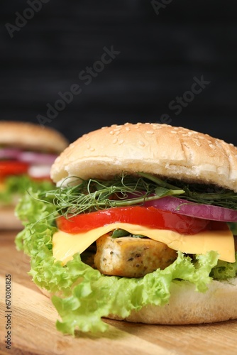 Delicious burger with tofu and fresh vegetables on wooden table, closeup