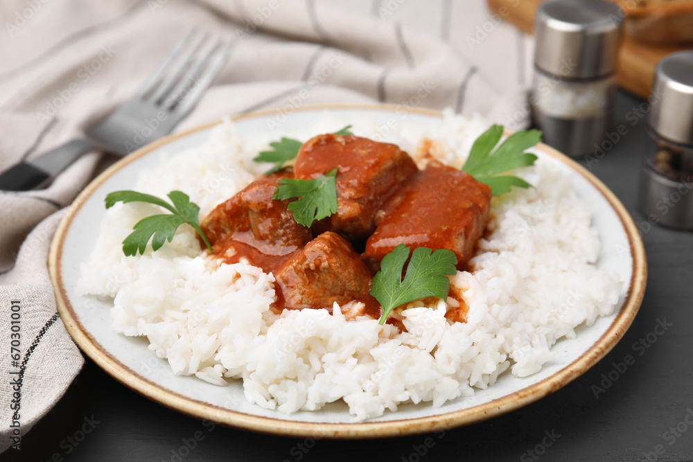 Delicious goulash served with rice on grey wooden table, closeup Delicious goulash served with rice on grey wooden table, closeup