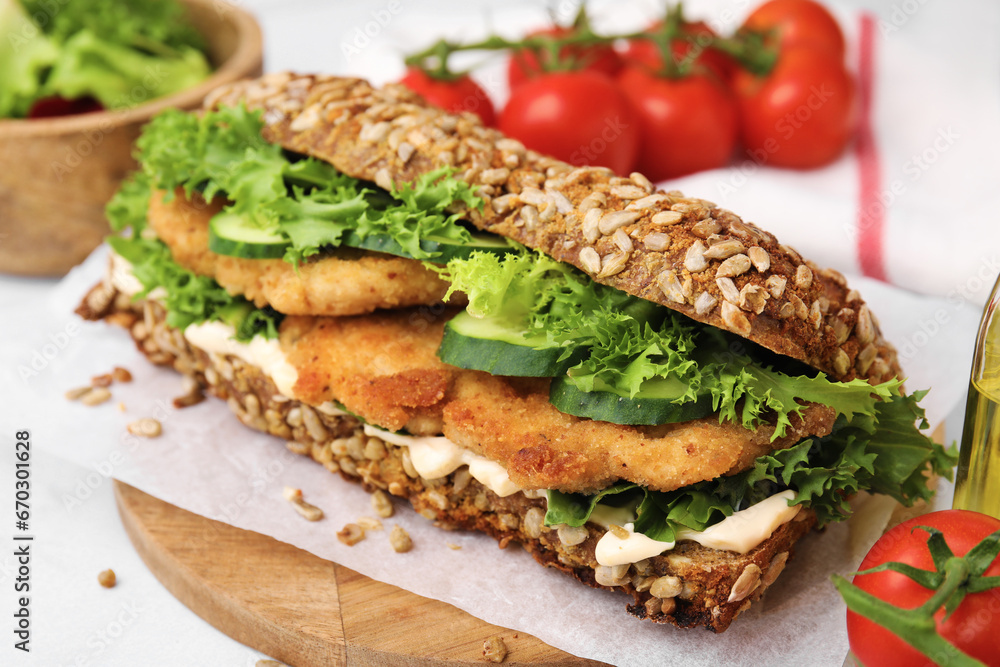 Delicious sandwich with schnitzel on white table, closeup Delicious sandwich with schnitzel on white table, closeup