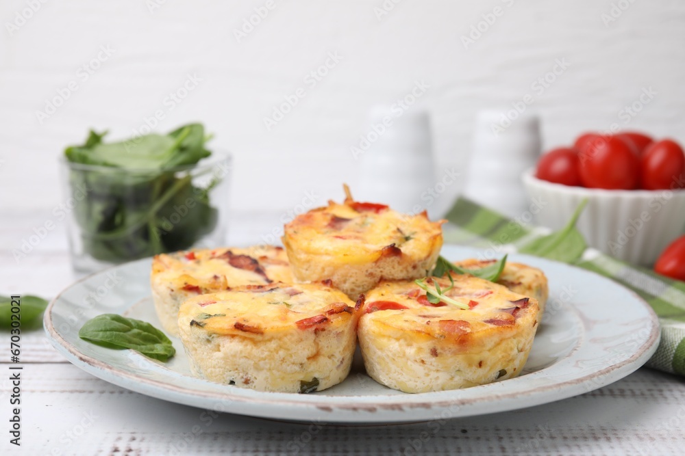 Delicious egg muffins with cheese and bacon on white wooden table, closeup. Space for text
